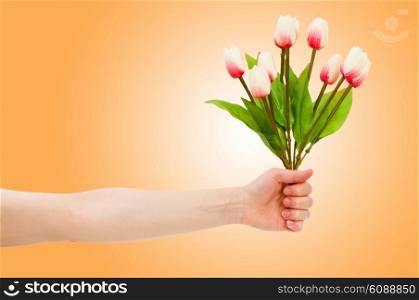 Hand with tulips on gradient