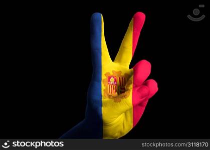 Hand with two finger up gesture in colored andorra national flag as symbol of winning, victorious, excellent, - for tourism and touristic advertising, positive political, cultural, social management of country