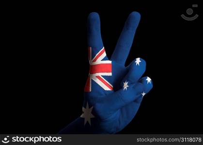 Hand with two finger up gesture in colored australia national flag as symbol of winning, victorious, excellent, - for tourism and touristic advertising, positive political, cultural, social management of country