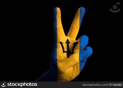 Hand with two finger up gesture in colored barbados national flag as symbol of winning, victorious, excellent, - for tourism and touristic advertising, positive political, cultural, social management of country