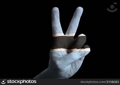 Hand with two finger up gesture in colored botswana national flag as symbol of winning, victorious, excellent, - for tourism and touristic advertising, positive political, cultural, social management of country