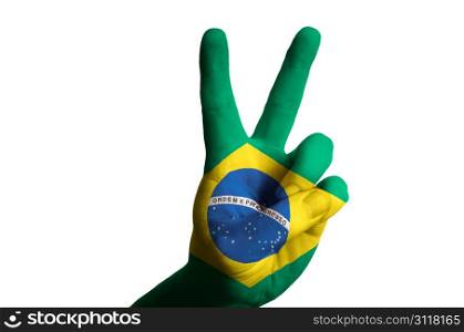 Hand with two finger up gesture in colored brazil national flag as symbol of winning, victorious, excellent, - for tourism and touristic advertising, positive political, cultural, social management of country