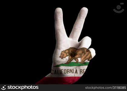 Hand with two finger up gesture in colored california state flag as symbol of winning, victorious, excellent, - for tourism and touristic advertising, positive political, cultural, social management of country