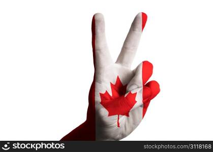 Hand with two finger up gesture in colored canada national flag as symbol of winning, victorious, excellent, - for tourism and touristic advertising, positive political, cultural, social management of country