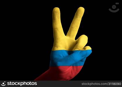 Hand with two finger up gesture in colored colombia national flag as symbol of winning, victorious, excellent, - for tourism and touristic advertising, positive political, cultural, social management of country