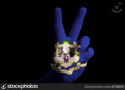 Hand with two finger up gesture in colored connecticut state flag as symbol of winning, victorious, excellent, - for tourism and touristic advertising, positive political, cultural, social management of country
