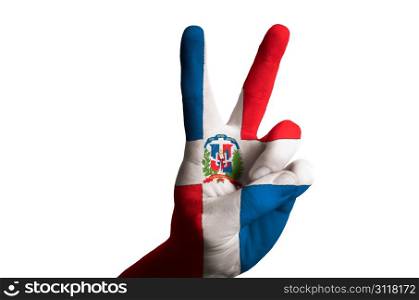 Hand with two finger up gesture in colored dominican national flag as symbol of winning, victorious, excellent, - for tourism and touristic advertising, positive political, cultural, social management of country