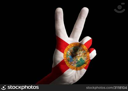 Hand with two finger up gesture in colored florida state flag as symbol of winning, victorious, excellent, - for tourism and touristic advertising, positive political, cultural, social management of country