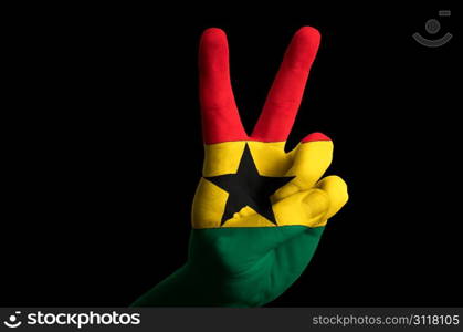 Hand with two finger up gesture in colored ghana national flag as symbol of winning, victorious, excellent, - for tourism and touristic advertising, positive political, cultural, social management of country