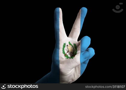 Hand with two finger up gesture in colored guatemala national flag as symbol of winning, victorious, excellent, - for tourism and touristic advertising, positive political, cultural, social management of country