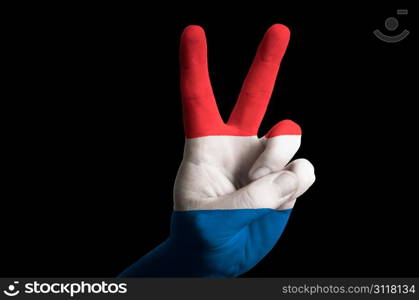 Hand with two finger up gesture in colored holland national flag as symbol of winning, victorious, excellent, - for tourism and touristic advertising, positive political, cultural, social management of country