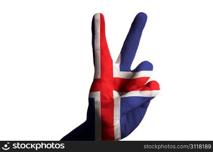 Hand with two finger up gesture in colored iceland national flag as symbol of winning, victorious, excellent, - for tourism and touristic advertising, positive political, cultural, social management of country