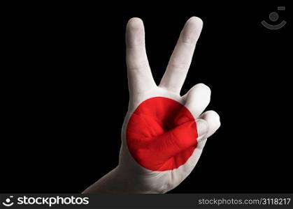 Hand with two finger up gesture in colored japan national flag as symbol of winning, victorious, excellent, - for tourism and touristic advertising, positive political, cultural, social management of country