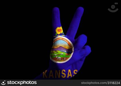 Hand with two finger up gesture in colored kansas state flag as symbol of winning, victorious, excellent, - for tourism and touristic advertising, positive political, cultural, social management of country
