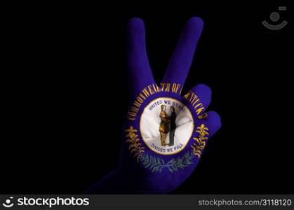 Hand with two finger up gesture in colored kentucky state flag as symbol of winning, victorious, excellent, - for tourism and touristic advertising, positive political, cultural, social management of country