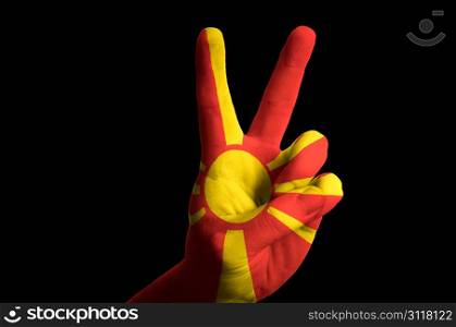 Hand with two finger up gesture in colored macedonia national flag as symbol of winning, victorious, excellent, - for tourism and touristic advertising, positive political, cultural, social management of country