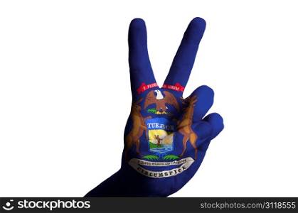 Hand with two finger up gesture in colored michigan state flag as symbol of winning, victorious, excellent, - for tourism and touristic advertising, positive political, cultural, social management of country
