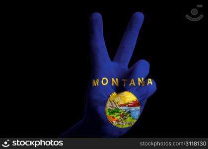 Hand with two finger up gesture in colored montana state flag as symbol of winning, victorious, excellent, - for tourism and touristic advertising, positive political, cultural, social management of country