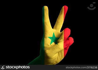 Hand with two finger up gesture in colored senegal national flag as symbol of winning, victorious, excellent, - for tourism and touristic advertising, positive political, cultural, social management of country