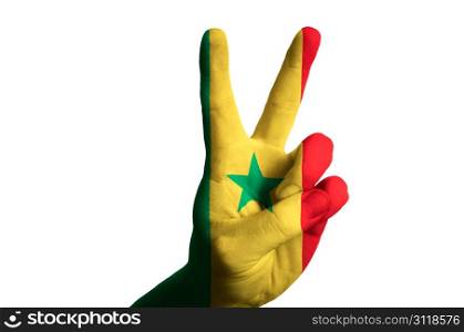 Hand with two finger up gesture in colored senegal national flag as symbol of winning, victorious, excellent, - for tourism and touristic advertising, positive political, cultural, social management of country