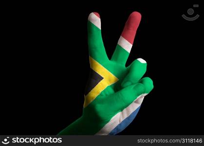 Hand with two finger up gesture in colored south africa national flag as symbol of winning, victorious, excellent, - for tourism and touristic advertising, positive political, cultural, social management of country