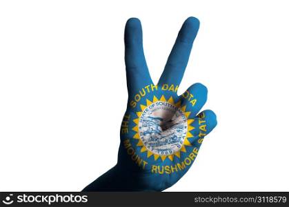 Hand with two finger up gesture in colored south dakota american state flag as symbol of winning, victorious, excellent, - for tourism and touristic advertising, positive political, cultural, social management of country