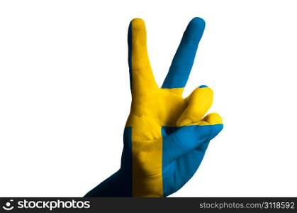 Hand with two finger up gesture in colored sweden national flag as symbol of winning, victorious, excellent, - for tourism and touristic advertising, positive political, cultural, social management of country