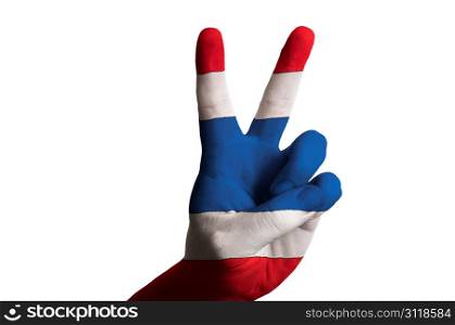 Hand with two finger up gesture in colored thailand national flag as symbol of winning, victorious, excellent, - for tourism and touristic advertising, positive political, cultural, social management of country