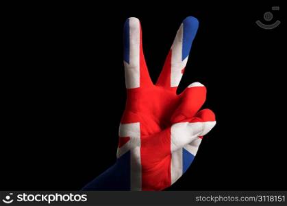 Hand with two finger up gesture in colored uk national flag as symbol of winning, victorious, excellent, - for tourism and touristic advertising, positive political, cultural, social management of country