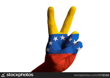 Hand with two finger up gesture in colored venezuela national flag as symbol of winning, victorious, excellent, - for tourism and touristic advertising, positive political, cultural, social management of country