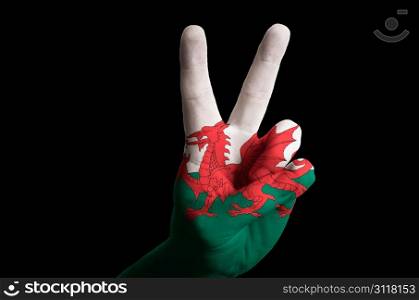 Hand with two finger up gesture in colored wales national flag as symbol of winning, victorious, excellent, - for tourism and touristic advertising, positive political, cultural, social management of country