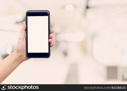 Hand woman holding and showing phone with blurred background in shopping mall.