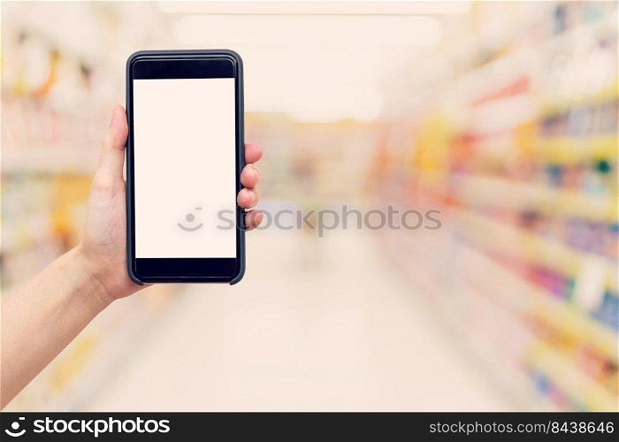 Hand woman holding and showing phone with blurred background in shopping mall.