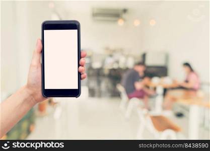 Hand woman holding phone with blank screen and blur coffee shop.