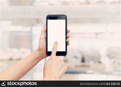 hand woman holding phone with blank screen and blur shopping mall.