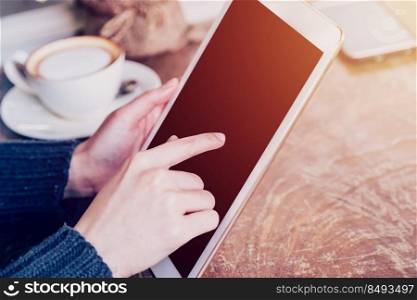 hand woman playing tablet in coffee shop with vintage tone.