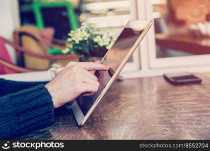 hand woman playing tablet in coffee shop with vintage tone.