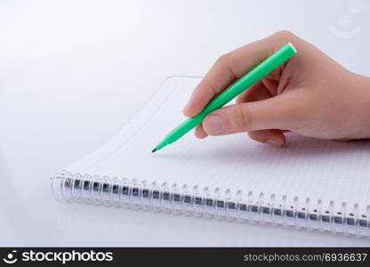 Hand writing on a Notebook with a pen on a white background