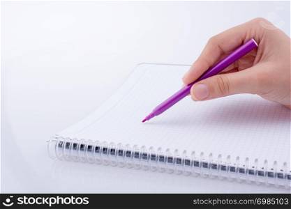 Hand writing on a Notebook with a pen on a white background