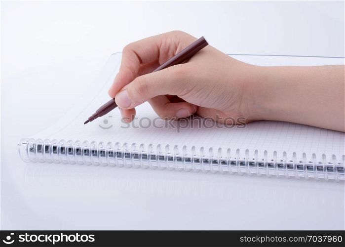Hand writing on a Notebook with a pen on a white background