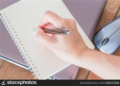 Hand writing on note paper at workplace, stock photo