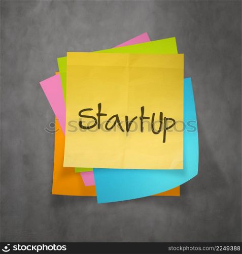 hand writing Startup business concept on sticky note paper