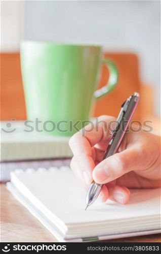 Hand writing with green mug background, stock photo