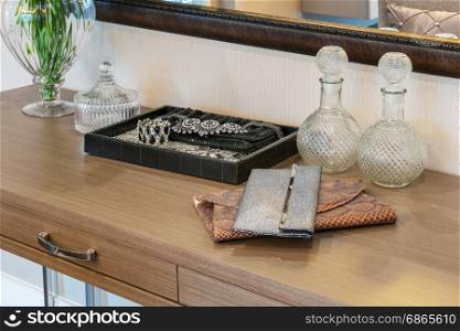 handbag and jewelry set on a dresser table in a contemporary room.