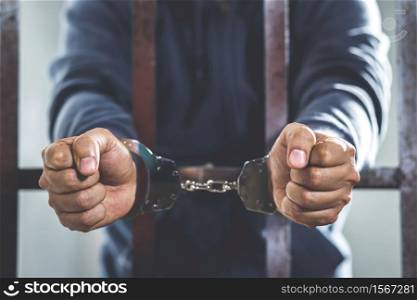 Handcuffed prisoner in jail