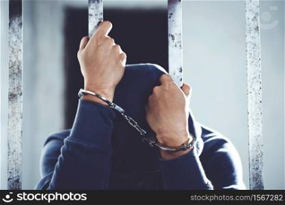 Handcuffed prisoner in jail