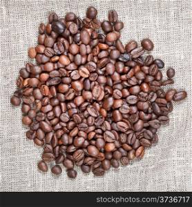 handful of roasted coffee beans on textile close up
