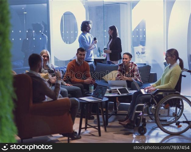 Handicapped businesswoman in a wheelchair on meeting with her diverse business team brainstorming about ideas and plans in a modern open space coworking office space. High quality photo. Handicapperd businesswoman in a wheelchair on meeting with her diverse business team brainstorming at office