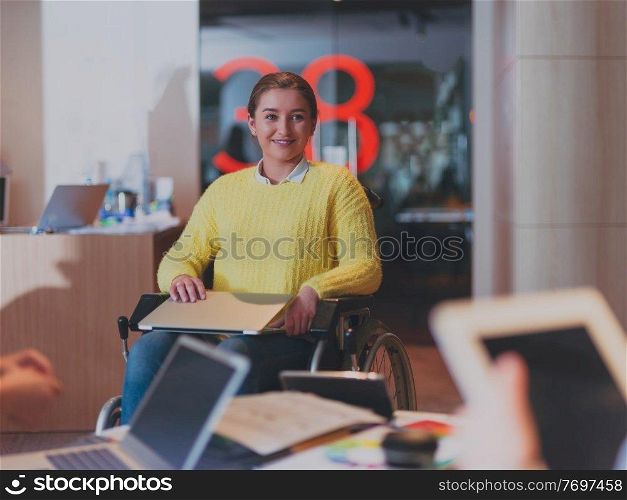 Handicapped businesswoman in a wheelchair on meeting with her diverse business team brainstorming about ideas and plans in a modern open space coworking office space. High quality photo. Handicapperd businesswoman in a wheelchair on meeting with her diverse business team brainstorming at office