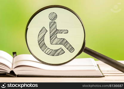 Handicapped info with a pencil drawing of a disabled icon in a magnifying glass
